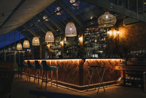 a bar with bar stools and chandeliers at Maplewood Cottage, Wynyard Hall in Grindon