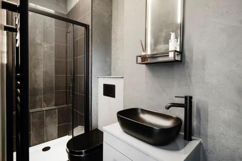 a bathroom with a black sink and a shower at High End Free Parking Wifi Balcony Ensuite in Cheltenham