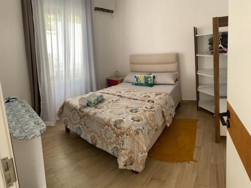 a small bedroom with a bed and a window at Sunny Side Up - Private 3BR villa with pool in Grand Baie