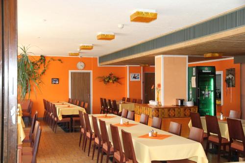 un restaurante con mesas, sillas y paredes de color naranja en Hotel Stille, en St. Moritz