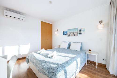 ポルティマンにあるPortimão Beach Houseの白いベッドルーム(青い毛布付きのベッド付)