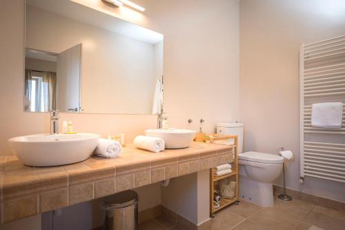 a bathroom with a sink and a mirror and a toilet at Hvaretta Villas in Stari Grad