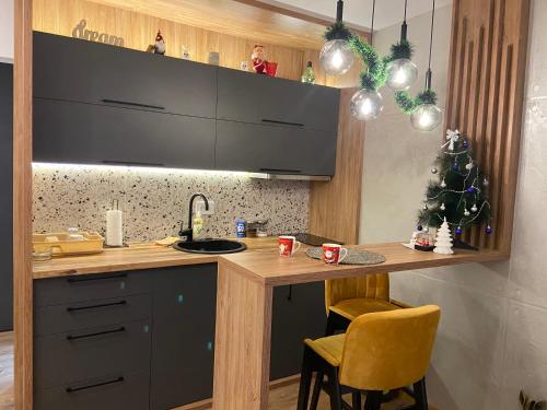a kitchen with a counter with a sink and a christmas tree at Gomax apartman 4 in Zlatibor