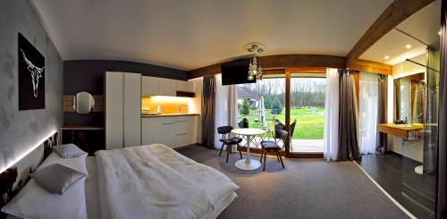 a bedroom with a bed and a table and a kitchen at AHA Jasná Apartmány in Liptovský Mikuláš