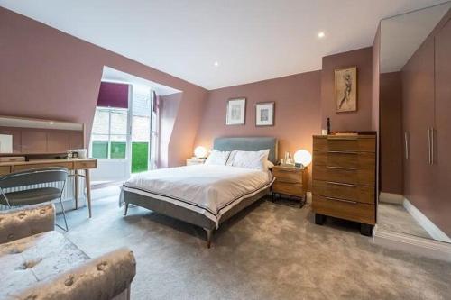 - une grande chambre avec un lit et un bureau dans l'établissement 3 Bedroom Modern Mews House, à Londres