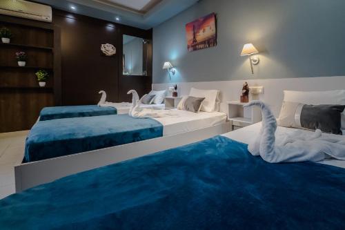 una camera con due letti e un tappeto blu di Cloud9 Hotel Shisha & Cocktail Bar - Adults Only a Mália