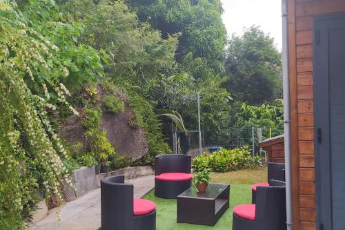 a group of stools sitting on the grass in a yard at KAZA-Nounours Location saisonnière in Le Bois de Nèfles