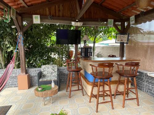 eine Bar mit Stühlen und einem TV auf einer Terrasse in der Unterkunft LOFTSCACAO APARTMENTS, Villas Cacao, near to Playa Bonita Limón in Portete