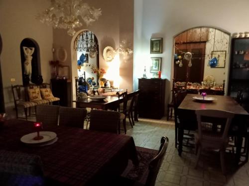 a dining room with tables and chairs and a chandelier at GRAZZANO ANTICA STAZIONE in Grazzano Visconti