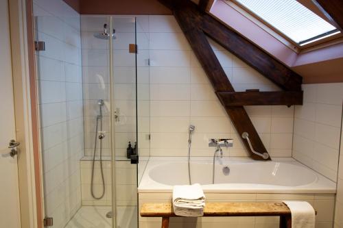 a bathroom with a shower and a bath tub at Suitehotel Pincoffs in Rotterdam