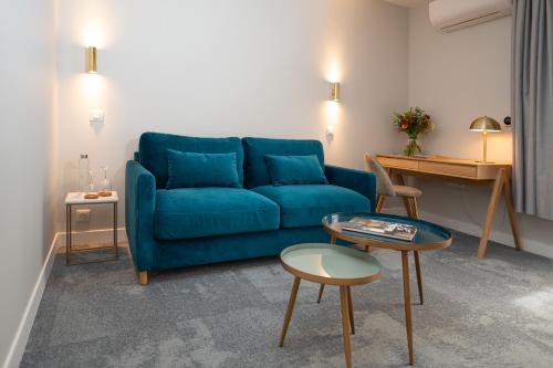 a living room with a blue couch and a table at Domaine et Golf de Vaugouard - La Maison Younan in Fontenay-sur-Loing