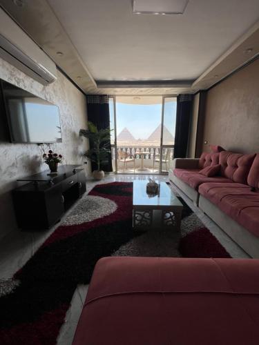 sala de estar con sofá rojo y mesa en Hi Pyramids, en El Cairo