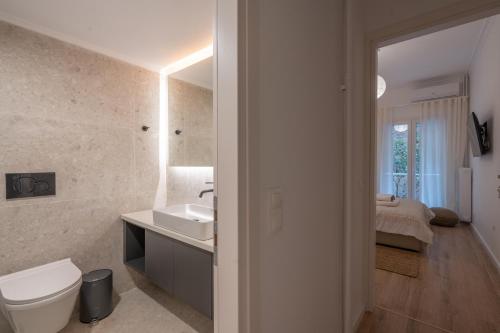 Unique 2 Bedrooms Apartment, Steps to Plaka and City center في أثينا: حمام مع حوض ومرحاض وغرفة نوم