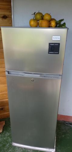 a white refrigerator with a pile of fruit on top of it at Berkey's Jungle Paradise in Roseau