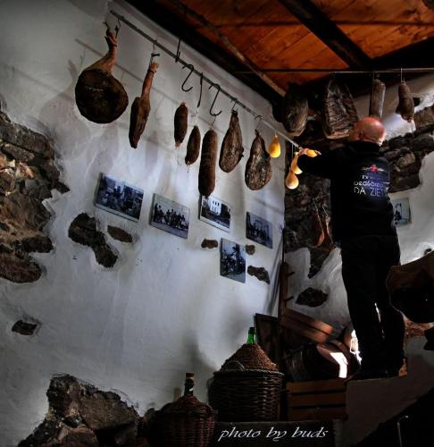a man standing in a room with a wall with artifacts at AFFITTACAMERE DORGALI B&B da ZIETTO in Dorgali