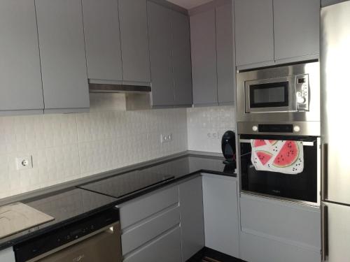 a kitchen with white cabinets and a microwave at Casanova in Fene