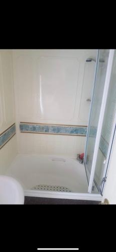 a bathroom with a shower with a white tub at Beachfront luxury holiday home in Skegness