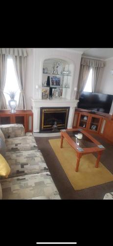 a living room with a couch and a coffee table at Beachfront luxury holiday home in Skegness