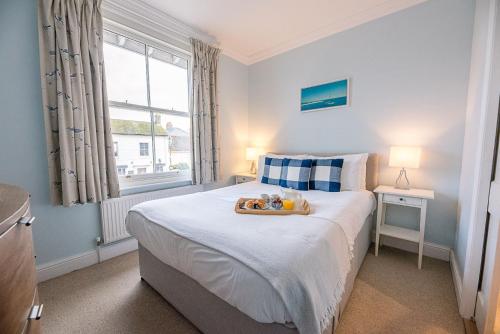 a bedroom with a bed with a tray of food on it at Pelican Cottage, Aldeburgh in Aldeburgh