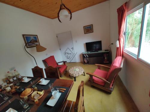 普爾馬馬卡的住宿－Rikra Purmamarca，客厅配有餐桌和椅子