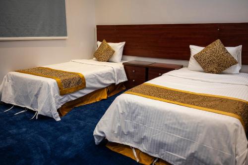 a hotel room with two beds in a room at Ahlin Suites 5 in Riyadh
