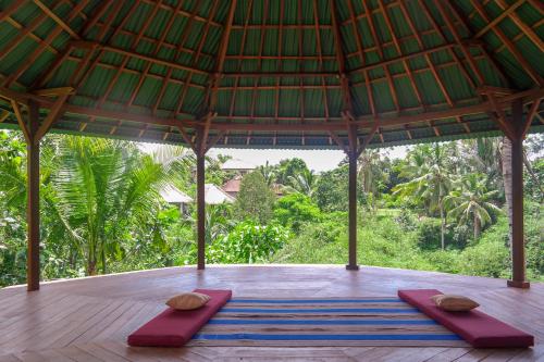 a meditation area in a pavilion with yoga mats at Ancut Garden in Ubud
