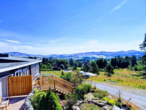 a house with a deck and a view of the mountains at Kaoglen Warren - Pet friendly - Hot Tub - Cairngorms in Blairgowrie