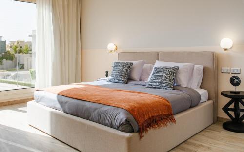 1 dormitorio con 1 cama grande con manta naranja en BIRD NEST at Sheikh Zayed en Sheikh Zayed