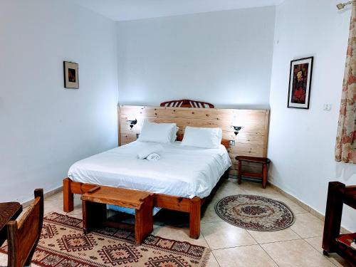 een slaapkamer met een wit bed en een houten hoofdeinde bij SHIR HACHORESh in Shomera