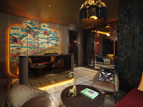 a lobby with a table and chairs and a painting at The Other House South Kensington in London