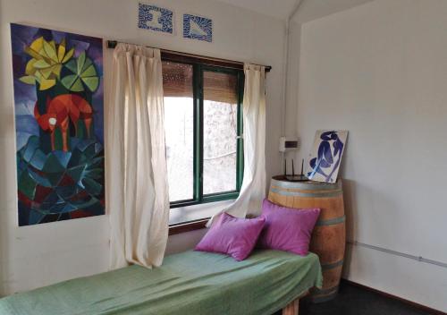 Habitación con ventana y sofá con almohadas moradas. en El Atelier - Valle de Uco en La Consulta
