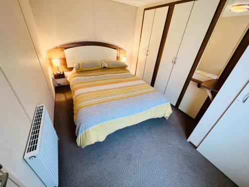 尚克林2 Bedroom Caravan NV16, Lower Hyde, Shanklin, Isle of Wight的一间小卧室,卧室内配有一张床铺
