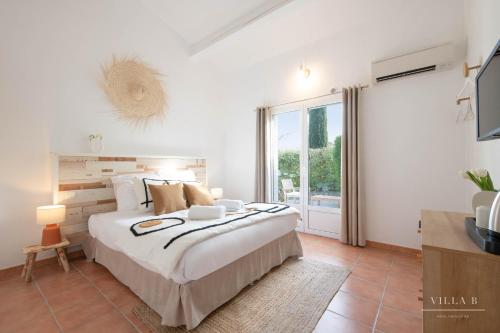 - une chambre avec un grand lit et une grande fenêtre dans l'établissement Villa B, à Salernes