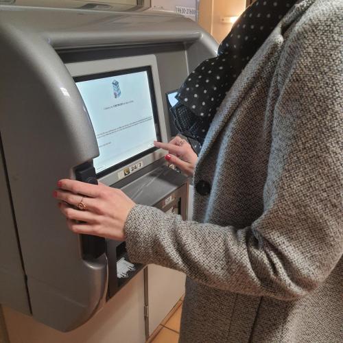 a person is using an atm machine at Kyriad Orthez in Orthez