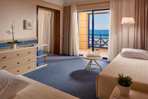 a hotel room with a bed and a view of the ocean at Aldemar Olympian Village in Olympia