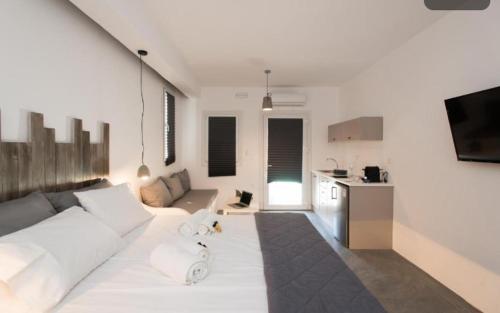 a living room with a white couch and a kitchen at Merchia Bay Villas Mykonos in Merchia Beach