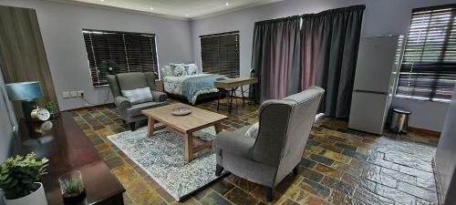 a living room with two chairs and a table at Studio View in Northwold