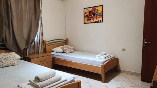 een kleine kamer met twee bedden en een foto aan de muur bij Guesthouse Villa Joanna&Mattheo in Sarandë