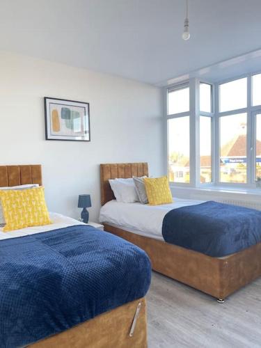 1 dormitorio con 2 camas y ventana en Flitwick Luxury Apartment, en Flitwick