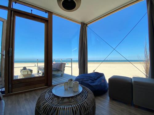 a living room with a view of the beach at Strandhuis, Beachhouse - Slapen op het strand, Sleep at the beach in Nieuwvliet