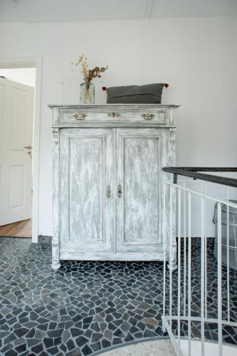a white cabinet in the corner of a room at Designapartment im Herzen der Altstadt - 7 Guests - 3 Bedrooms - 2 Bathrooms in Limburg an der Lahn