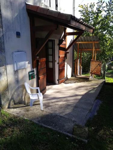 a white chair sitting in front of a building at Gîte du Rempart in Saint-Justin