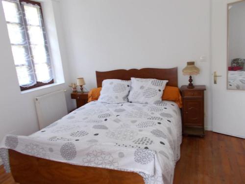 a bedroom with a bed with a white comforter and two windows at Gîte du Rempart in Saint-Justin