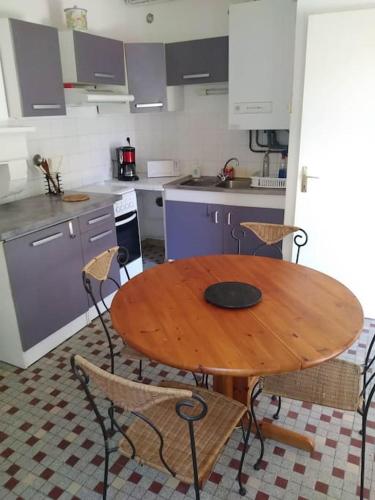 a kitchen with a wooden table and chairs at Gîte du Rempart in Saint-Justin
