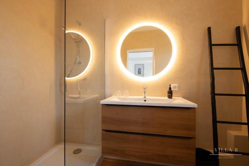La salle de bains est pourvue d'un lavabo et d'un miroir. dans l'établissement Villa B, à Salernes