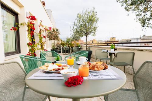 a table with food and orange juice on a balcony at Mercure Roma Piazza Bologna in Rome