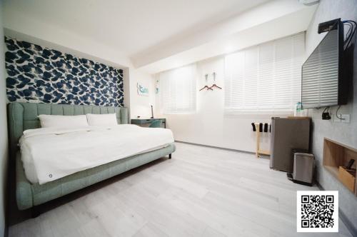 a bedroom with a white bed and a blue patterned wall at 虎尾小9窩 in Huwei