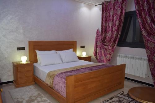 a bedroom with a bed with two night stands and two lamps at Moonrise Villa VIP Midelt in Midelt