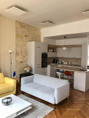 un salon avec un canapé blanc et une cuisine dans l'établissement Fantastic 3-Room apartment heart of les Chartrons - Bordeaux, à Bordeaux