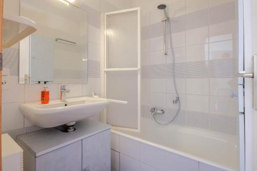 une salle de bain blanche avec un lavabo et une douche dans l'établissement PICARON A5, à Morzine